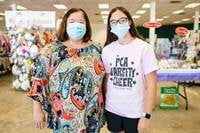A mother and daughter stand side by side in their masks as they shop their local JBF sale.